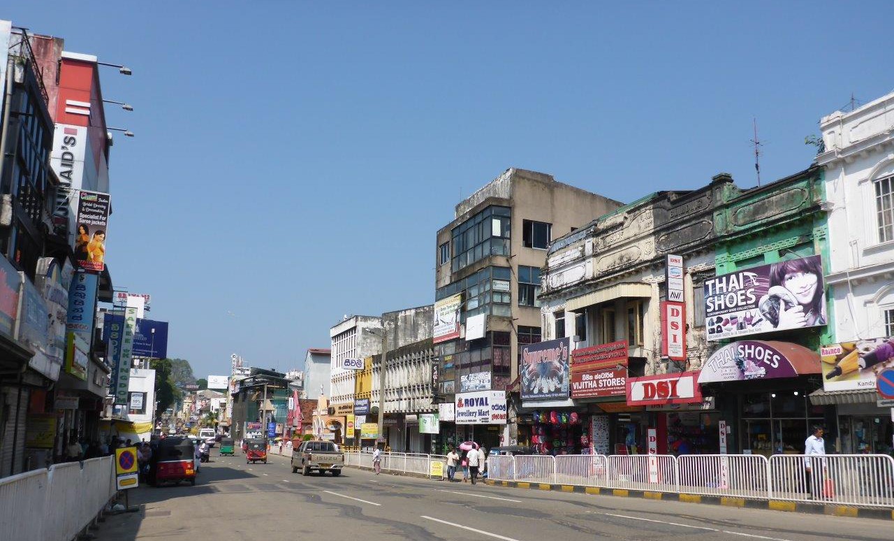 One of the main streets in Kandy, with plenty of commercial signs .