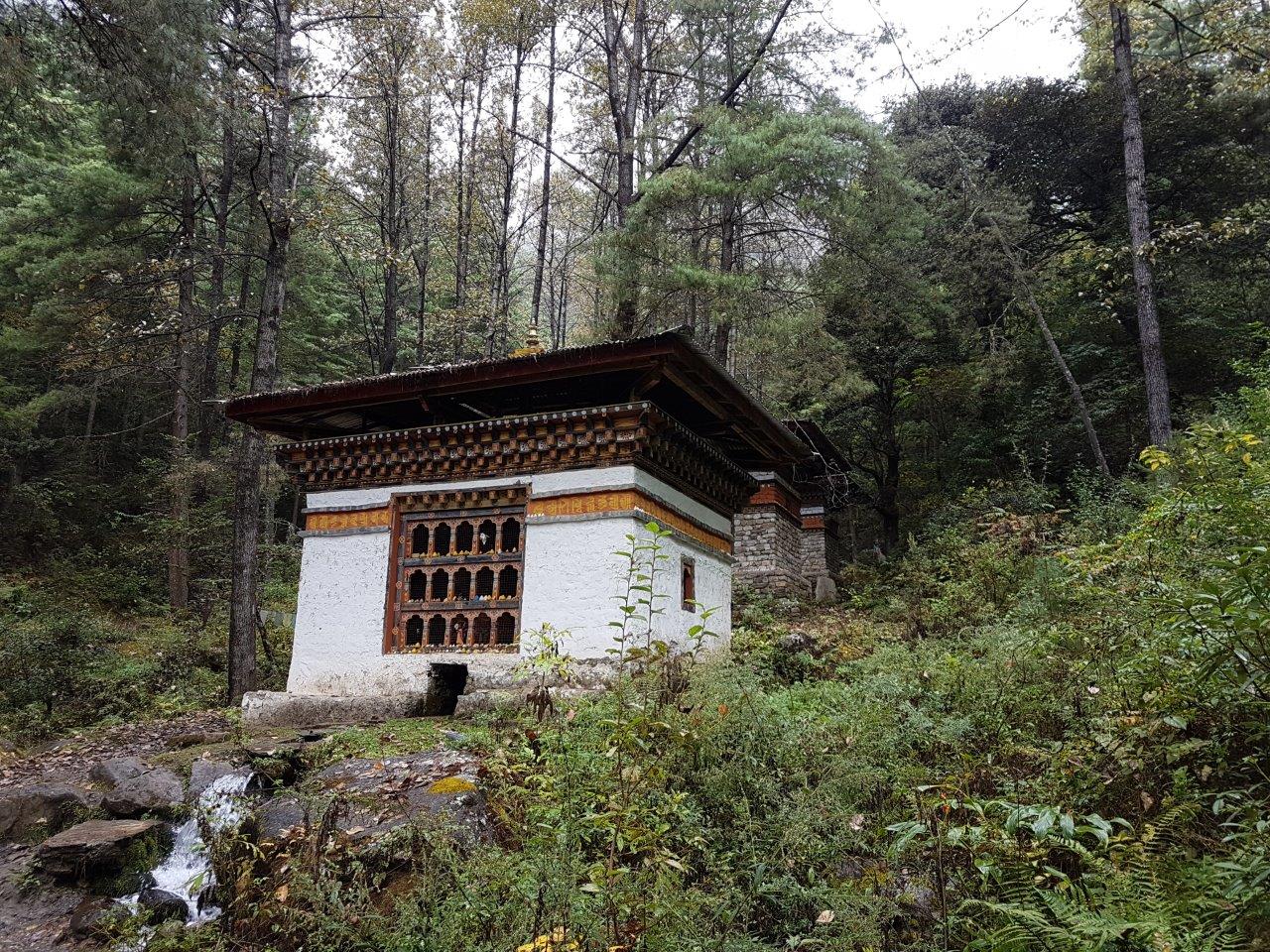 Three houses with prayer wheels rotated by the running stream.